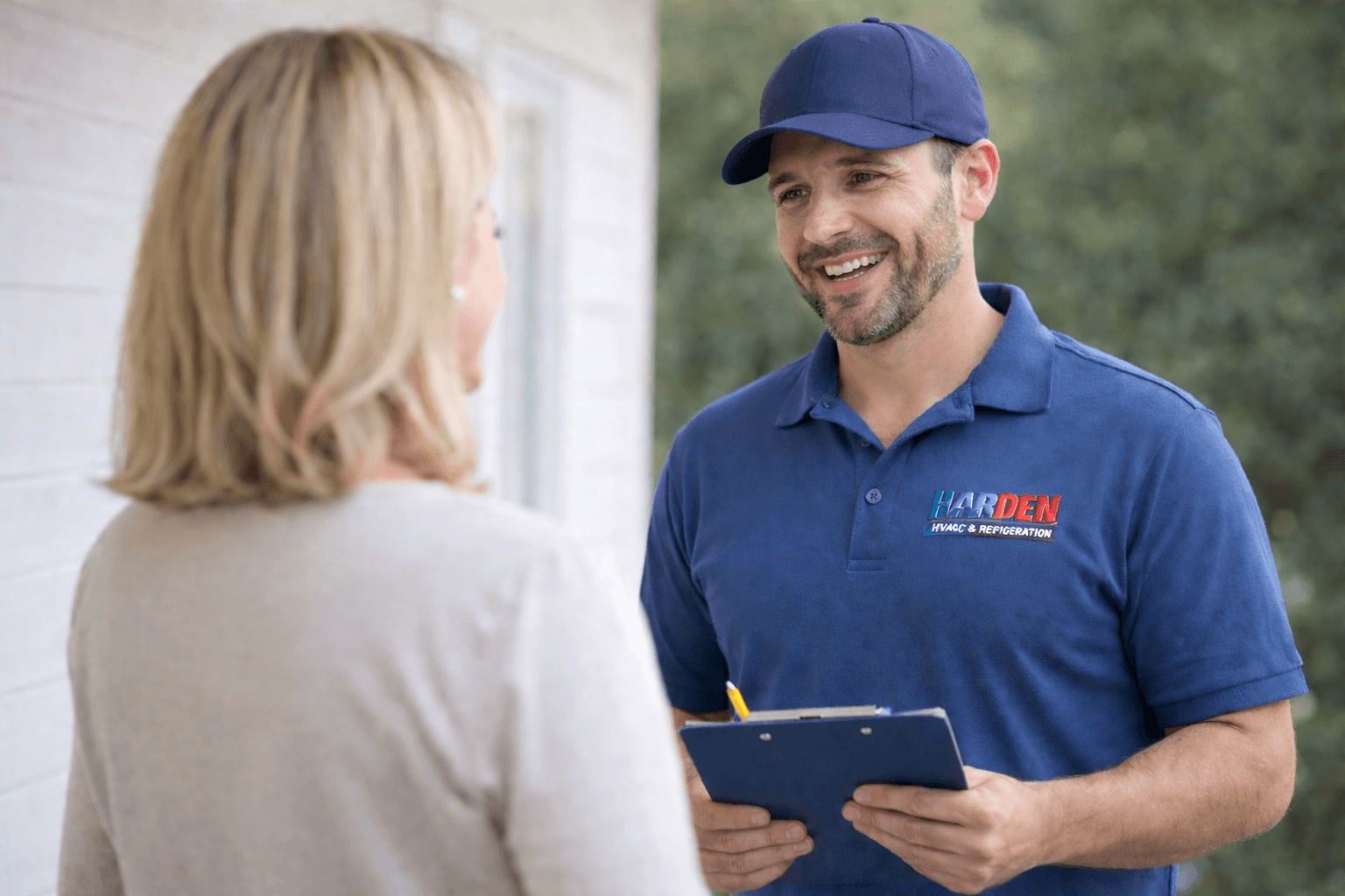 Harden HVAC technician greeting a customer at their home